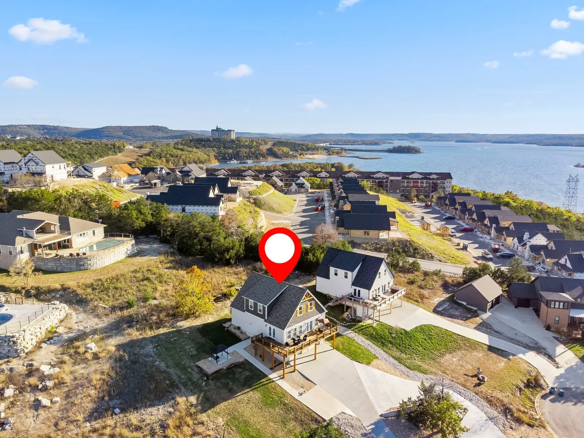 The exterior of the house showcases an inviting deck overlooking a scenic landscape with glimpses of the lake. The spacious deck is perfect for family gatherings, outdoor barbecues, and relaxing after a day of nearby adventures.
